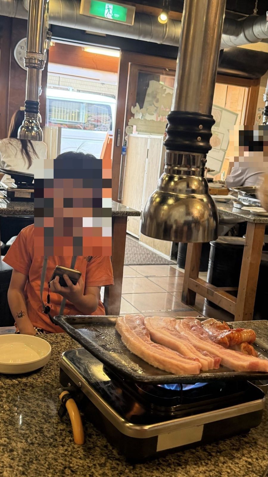 味ちゃんのテーブル。ガスコンロの鉄板で厚切りの豚バラとキムチを焼いている